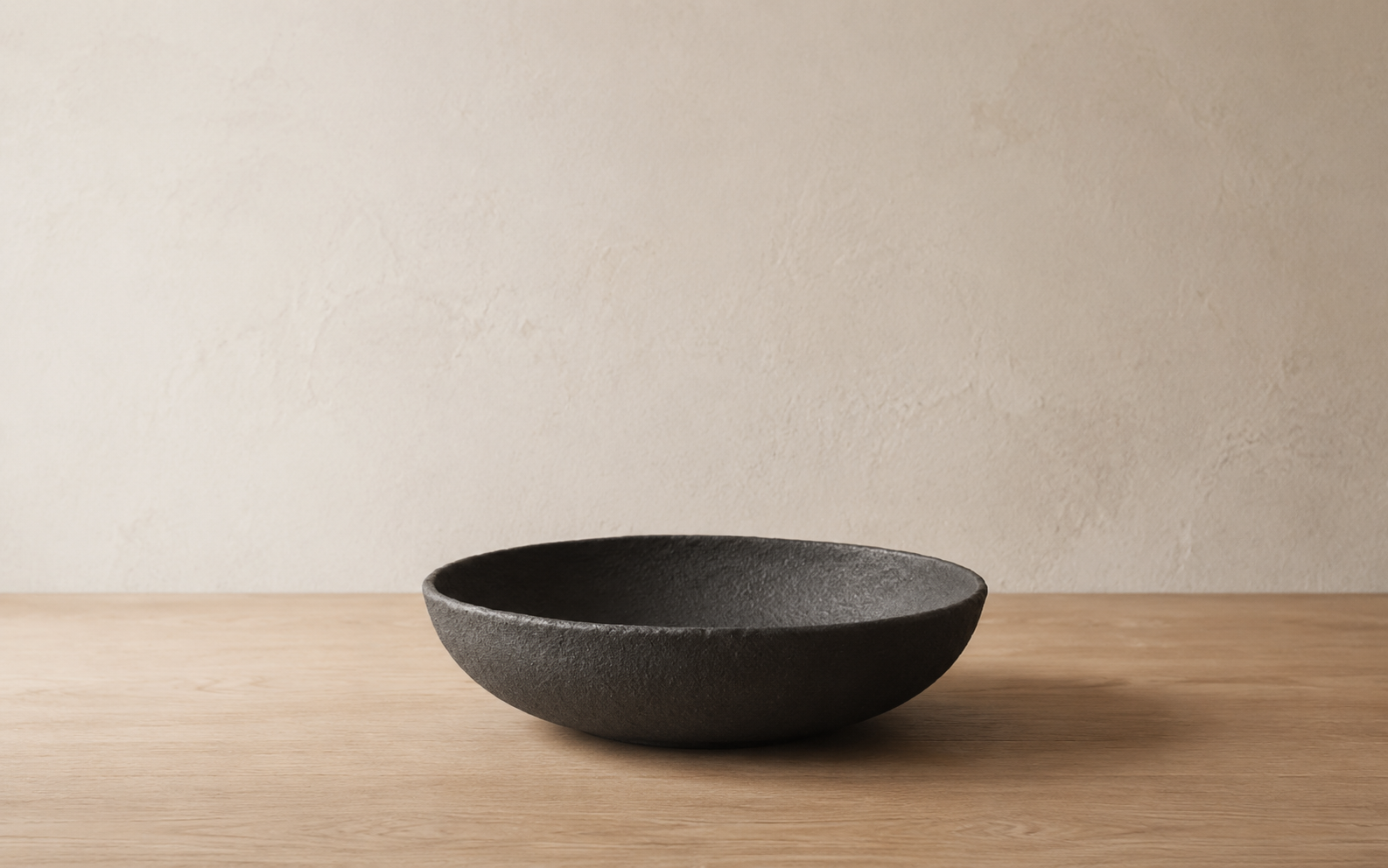 Handmade dark ceramic bowl resting in a quiet setting